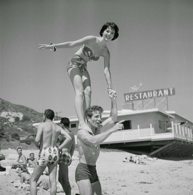 Натали Вуд стоит на плечах Стива Роуланда на пляже Малибу, Калифорния, 15 июля 1956 года. Фото Эрла Лифа