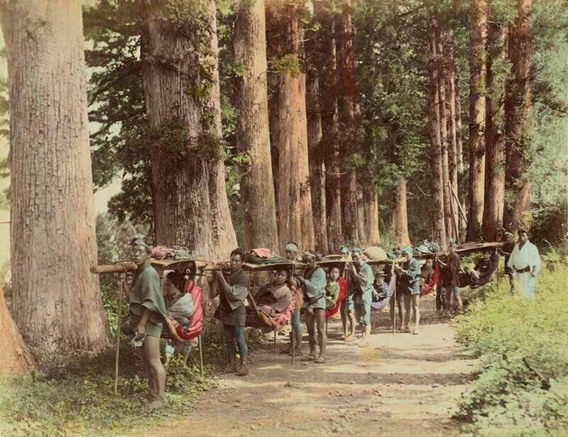 Кресло для путешествий каго. Мужчины несут длинный шест, на который подвешено несколько кресел , Япония, 1880-е