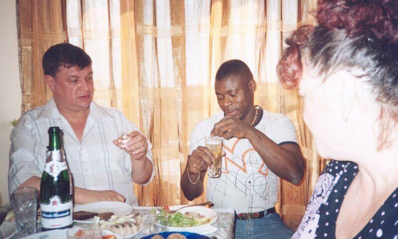 Лидер читинской ОПГ "Ключевские" Евгений Жаров, предпочитающий водку, с неодобрением смотрит на африканца, размешивающего шампанское