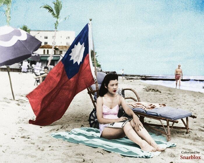Рут Ли, администратор китайского ресторана, установила китайский флаг, чтобы ее не приняли за японку пока она загорает на пляже в Майами. 15 декабря 1941 год