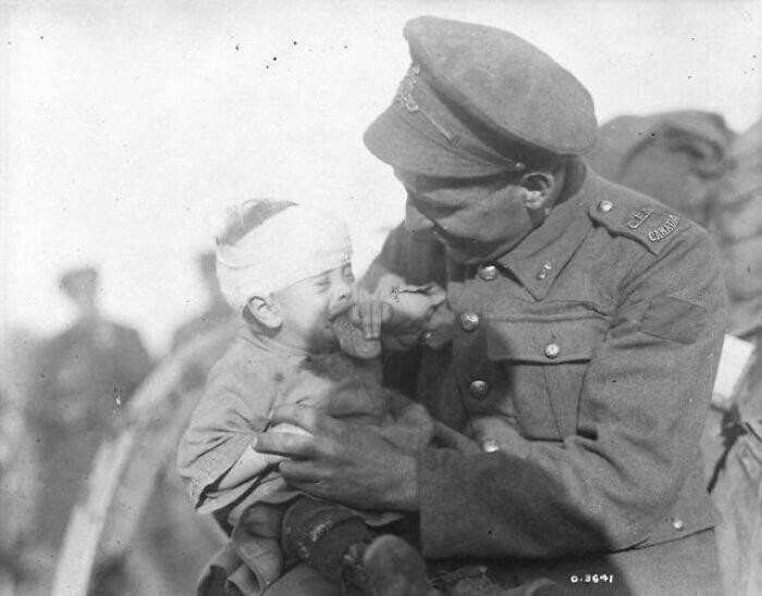 Первая мировая война. Канадский солдат утешает раненого бельгийского младенца, мать которого погибла от артиллерийского снаряда. Ноябрь 1918 года.