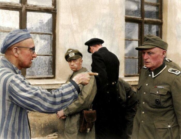 Русский освобожденный заключенный указывает на нацистского охранника, который особенно жестоко обходился с узниками в Бухенвальде