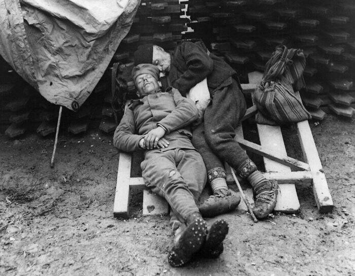 Сербский солдат спит рядом с отцом, который навестил его на передовой возле Белграда, 1914/1915 год