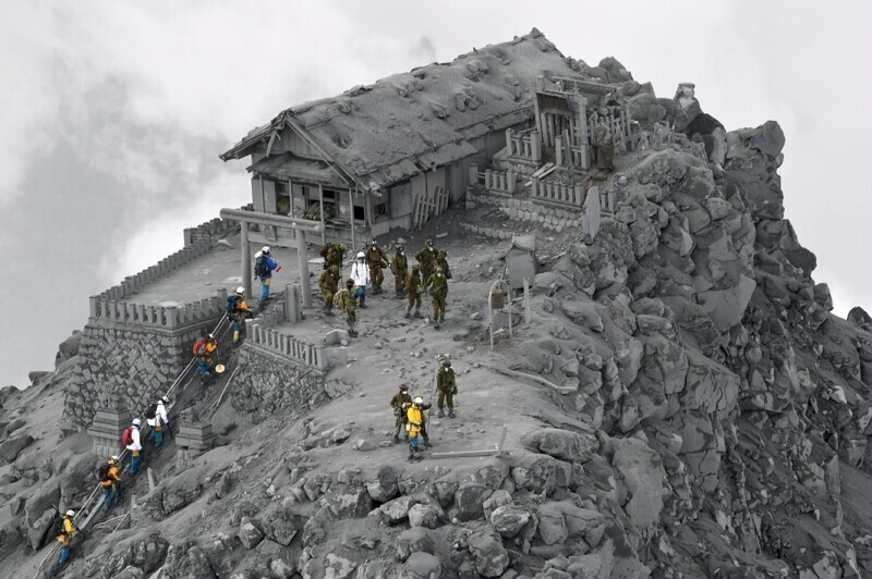 Спасатели у святилища на горе Онтаке, где произошло извержение вулкана, жертвами которого стал 51 человек