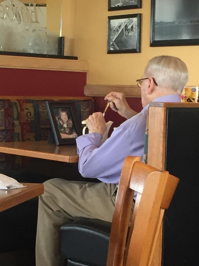 Мужчина делит ужин с фотографией своей умершей супруги